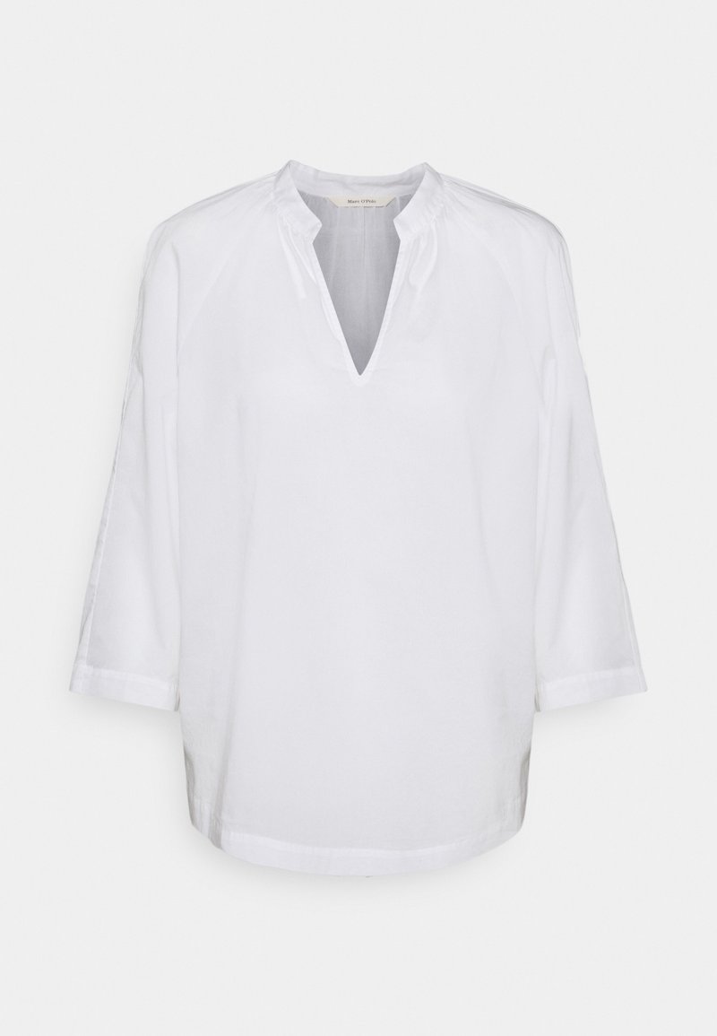 Blouse blanche à manches longues avec un col en V et un col froncé, présentant une coupe ample et un design simple.