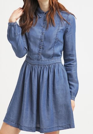 Jeanshemdjurk met een kraag, lange mouwen, knopen aan de voorkant en een gathering in de taille, met een uitlopende rok en een zachte textuur.