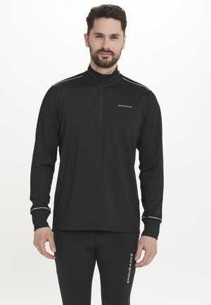 Zwarte sportieve top met lange mouwen en ritssluiting, voorzien van witte accenten en logo. Gladde stof, aansluitende pasvorm, hoge kraag, inclusief reflecterende details.