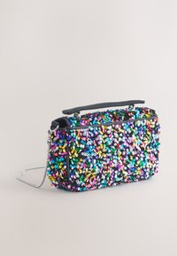 Maišelis su blizgučiais, stačiakampio formos, juodos spalvos pagrindas, įvairių spalvų blizgučiai įvairiais atspalviais. Yra grandinėlės dirželis ir viršutinė rankena.