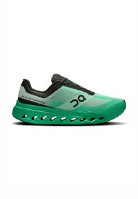 Grüner Sportschuh mit strukturiertem Obermaterial, schwarzen Akzenten und einer breiten, gepolsterten Sohle mit Belüftungslöchern für Atmungsaktivität.