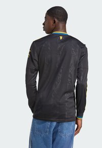Black long-sleeve jersey with textured pattern, yellow and blue accents on the collar and cuffs, made from lightweight, breathable fabric.