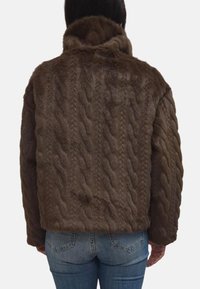 Giacca in pelliccia sintetica marrone a maglia con colletto alto, caratterizzata da una consistenza morbida e una vestibilità comoda. Mostrata da dietro con jeans blu.