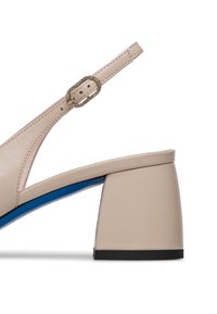 Scarpa beige in pelle con tacco a blocco, dotata di un accento blu, cinturino regolabile e una fibbia decorativa in oro con strass.