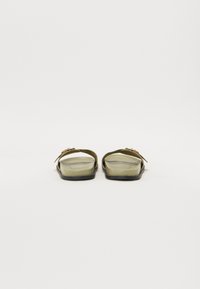 Green rubber sandals with a wide strap and a black sole. Features a simple design with a small decorative accent on each strap.