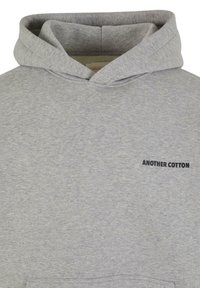 Hoodie din bumbac gri, cu un buzunar frontal și un logo de text negru "ANOTHER COTTON" în zona stângă a pieptului. Textură moale și design casual.
