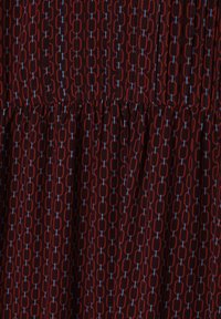 Tissu à motif rouge et noir mettant en avant des formes ovales liées avec des accents bleus, présentant une texture lisse et un design de taille froncée.