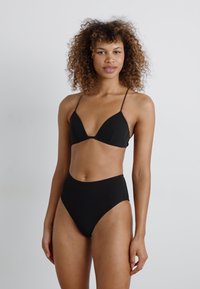 Svart bikiniset med trekantet bh-top med tynne stropper og høy midje. Glatt tekstur uten synlige mønstre eller detaljer.