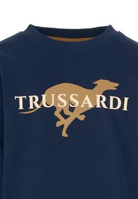 Sweatshirt bleu marine avec un graphique de lévrier beige courant et "TRUSSARDI" en texte blanc au-dessus du design. En coton.
