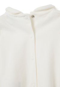 Ingrandimento di un body bianco per neonati con bottoni automatici lungo la parte anteriore e un collo morbido piegato.