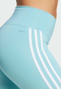 Svetlomodré legíny s vysokým pásom, zdobené troma bielymi pruhmi na boku, vyrobené z hladkého, pružného materiálu s označením "AEROREADY."