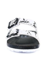 Sandali in stile Birkenstock con cinturini in vernice bianca a macchie, fibbie nere, soletta sagomata e suola scura. Design piatto con vestibilità regolabile.