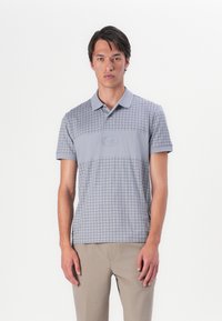 Graues Poloshirt mit Karomuster, hergestellt aus weichem Material. Verfügt über einen Kragen, kurze Ärmel und ein dezentes Logo auf der Brust.