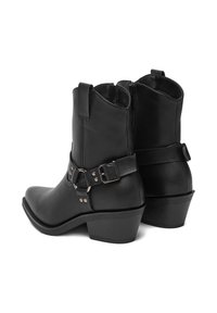 Czarne skórzane botki do kostki z nachyloną cholewką, dekoracyjnym paskiem i metalowymi akcentami oraz blokowym obcasem dla stabilności. Gładka faktura i elegancki design.