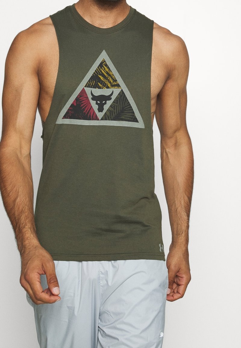 Olive green sleeveless tank top featuring a triangular graphic in black, yellow, and red with a bull logo at the center. Soft fabric texture.