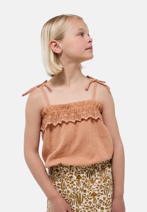 Débardeur couleur pêche avec bordure en dentelle et bretelles réglables à nouer, associé à une jupe à motif floral avec des accents aux tons naturels.