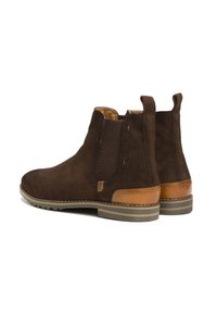 Bottines en suède marron avec des panneaux latéraux élastiques, des accents en cuir marron et une semelle en caoutchouc texturé, dotées d'une languette pour un enfilage facile.