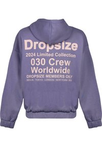 Lilla kapuutsviidiga dressipluus, mille seljal on suur roosa kiri, sealhulgas "Dropsize" ja "2024 Limited Collection". Ribiga mansetid ja äär.