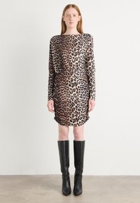 Beżowo-brązowa sukienka w leopardzi wzór z długim rękawem, dopasowana w talii z drapowanym detalem, w połączeniu z wysokimi na kolana czarnymi skórzanymi botkami.