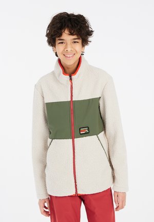Fleece-Jacke mit einem cremefarbenen Körper und einem grünen Einsatz, Reißverschluss vorne, hohem Kragen und roten Akzenten. Logo-Patch auf der Brust.