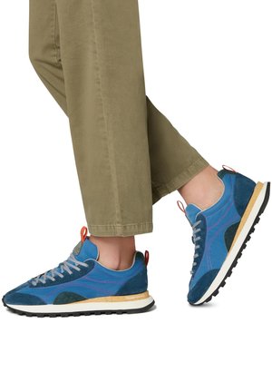 Blaue und türkisfarbene Sneakers aus Wildleder und Mesh-Materialien, mit kontrastierendem lila Nähten, einer cremefarbenen Sohle und einem roten Fersenetikett.