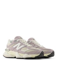 Αθλητικά παπούτσια New Balance σε ανοιχτό μοβ σουέντ και δίχτυ με κρεμ μεσαία σόλα, διακοσμημένα με λευκές λεπτομέρειες λογότυπου και εξωτερική σόλα από υφή καουτσούκ.