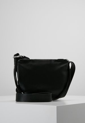 Czarna skórzana torba na ramię o miękkiej fakturze, z regulowanym paskiem i minimalistycznym metalowym wykończeniem. Gładki, usztywniony kształt bez widocznych wzorów.