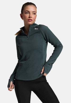 Dark green quarter-zip athletic top with textured sleeves, featuring a fitted design, thumbholes, and subtle brand logo on the collar.