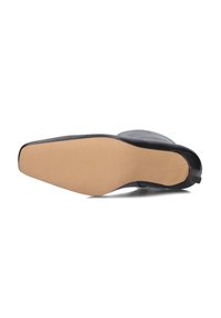 Zwarte leren enkelboot met een spitse neus, een gladde afwerking en een beige rubberen zool. Kenmerkt zich door minimale details en een slanke silhoutte.