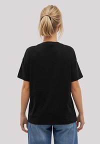 Black cotton t-shirt with a relaxed fit, short sleeves, and a crew neckline. Features a smooth texture and simple design without embellishments.