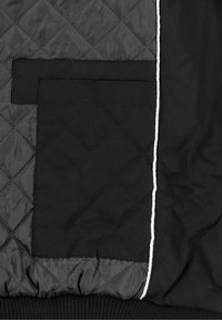 Czarna pikowana kurtka z poziomym przeszyciem, dużą kieszenią po lewej stronie oraz białą lamówką wzdłuż zamka.