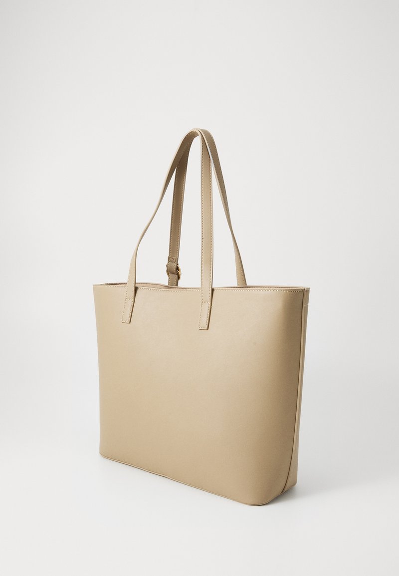 Bolso tote beige hecho de material sintético suave, con dos asas largas y una forma rectangular estructurada. Sin patrones ni acentos.