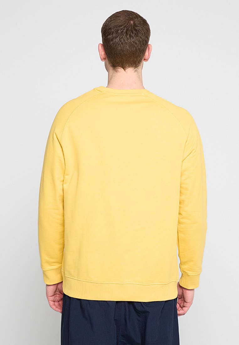 Felpa gialla con collo a giro, maniche raglan, polsini e fondo a costine, realizzata in morbido cotone testurizzato.