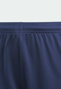 Navy blue urheilusortsit, jotka on valmistettu kevyestä kankaasta ja joissa on joustava vyötärö. Sortseissa on hienovaraisia tekstuuri- ja tikkaustyynyjä.