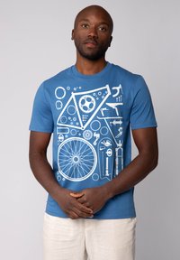 T-shirt en coton bleu avec un design graphique blanc représentant des composants de vélo, des engrenages et des outils, avec un col rond et des manches courtes.