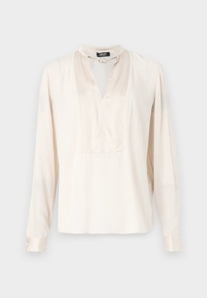Blusa a maniche lunghe di colore crema in tessuto satinato, con un alto colletto decorato da una catena e un'apertura a V, dal taglio morbido.