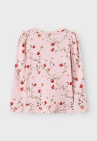 Ilgaaulio rožinė palaidinė, pagaminta iš minkštos medžiagos, su gėlių raštu, kuriame matyti raudonos rožės ir žalios vijoklinės augalijos. Pūkuotos rankovės ir apvalus iškirpimas.