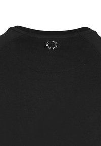 Camiseta negra con cuello redondo y un logo circular con texto blanco que dice "NO TE METAS CON NOSOTROS" en la parte posterior. Textura de tela suave.