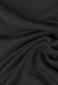 Tela negra con una superficie suave y ligeramente texturada, que presenta un caído suave y fluido con un brillo sutil.