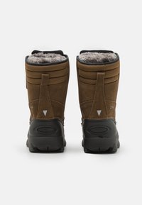 Stivali in suede marrone per l'inverno con suole in gomma nera, foderati in morbido grigio e con rinforzi sul tallone. Presentano doppie linguette per facilitarne l'indossamento.