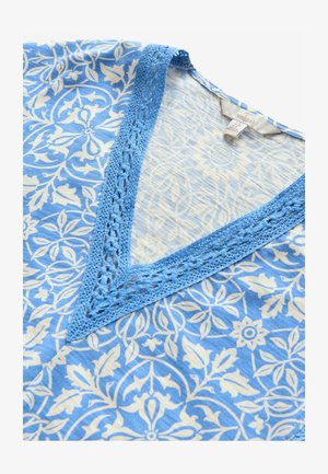 V-ringad tunika med ett blått och vitt blommönster, med en texturerad blå virkad kant längs halsringningen. Mjuk, lättviktsmaterial.