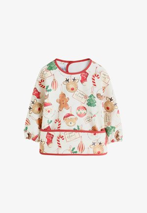 Baby die een kerstthema slab draagt met patronen van de kerstman, hulst, zuurstokje, peperkoek en kerstkous.