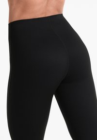 Leggings negre dintr-un material elastic, cu o textură netedă, talie înaltă și cusături plate pentru confort.