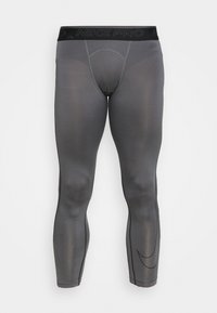 Leggings Nike Pro grises con una cinturilla negra. Hechos de material elástico, presentan un ajuste ceñido y una textura suave, con detalles de logotipo.