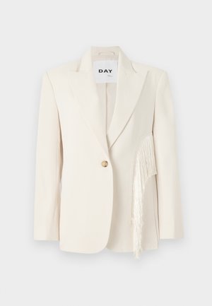 Blazer crema con rever a punta, chiusura con un singolo bottone e dettagli in frange laterali. Tessuto liscio, vestibilità su misura e design minimalista.