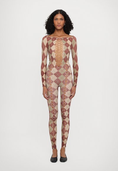 Bodysuit moulant avec des motifs en diamant rouge et beige. Présente des découpes circulaires sur les côtés. Manches longues, décolleté arrondi.