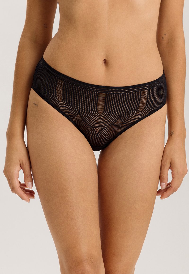 Slip in pizzo nero trasparente con un motivo a onde, una cintura elastica liscia e un design a taglio alto per una vestibilità moderna.