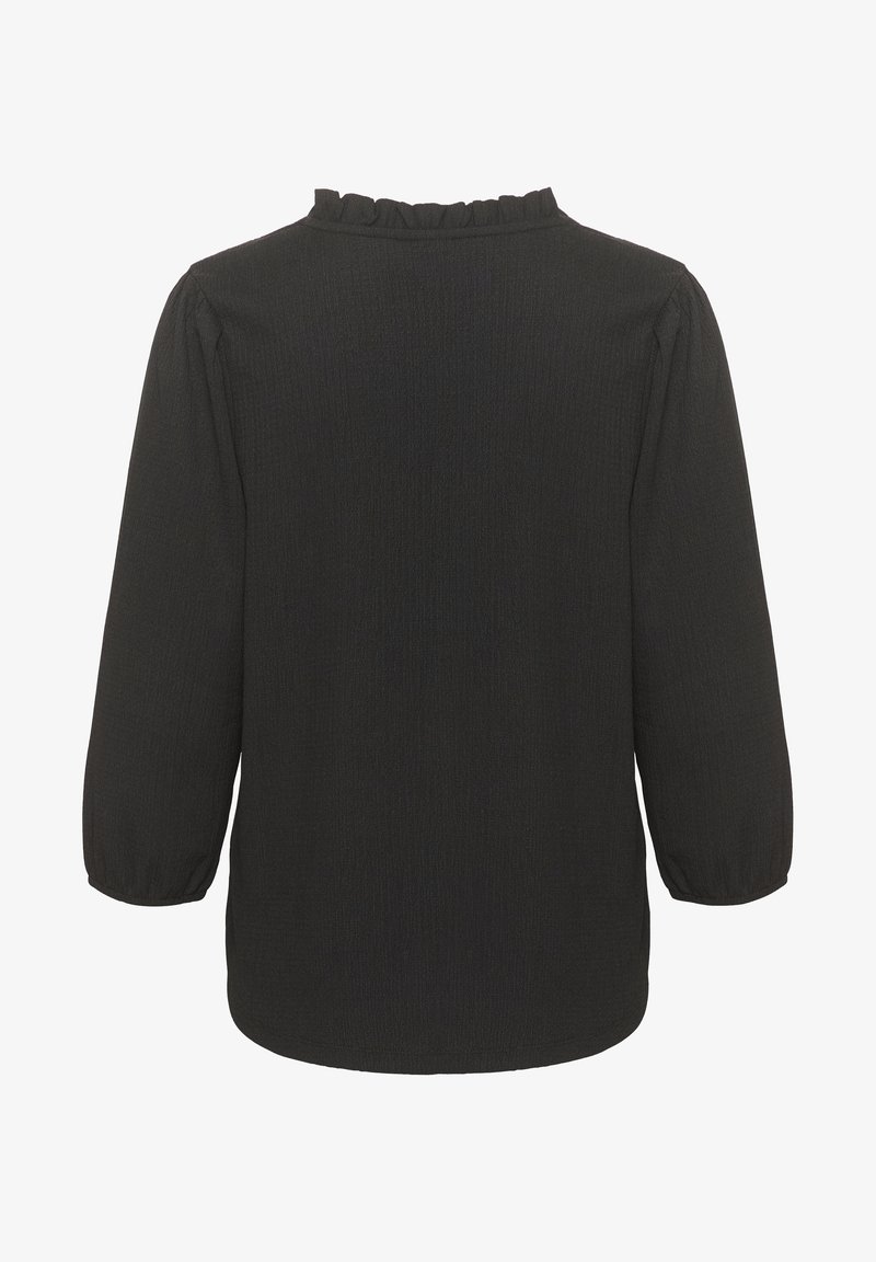 Blouse noire à manches longues avec poignets froncés et un petit détail volanté le long de l'encolure ronde, vue de dos.