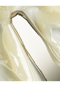 Matériau transparent et brillant de couleur jaune pâle, façonné de manière fluide avec des courbes lisses et un bord métallique réfléchissant, créant un design élégant et moderne.