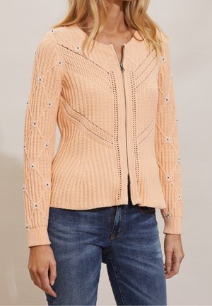 Persisk farvet strikket sweater med lynlås foran, udstyret med geometri mønstre og perle detaljer på ærmerne. Ribbede tekstur, tætsiddende design.